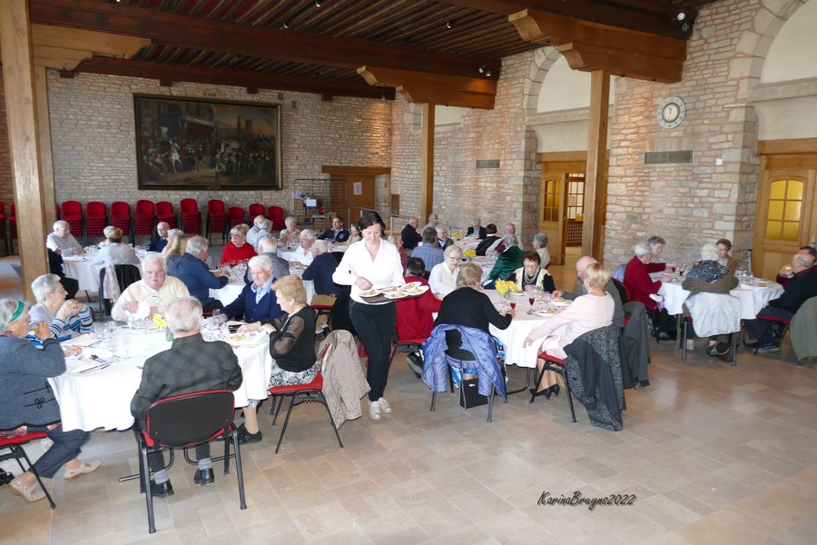 les aînés de la commune assis autour de table ronde dans la salle des fêtes